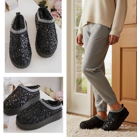 Black sequin slippers shown on a white surface and worn by a person  indoors. Cosy Faux Fur Lined