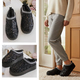 Black sequin slippers shown on a white surface and worn by a person  indoors. Cosy Faux Fur Lined