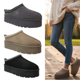 Three pairs of platform slippers in gray, brown, and black on a white background. A person wearing blue jeans and a beige sweater is also shown wearing the brown platform slipper.