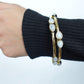 Teardrop Moonstone Brass Cuff - Sleek gold-tone brass cuff with teardrop moonstones in minimalist design.